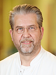 Porträt Oberarzt Dr. Prüter, Mann mittleren Alters mit Bart und Brille