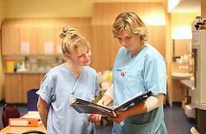 Zwei Schwestern schauen in eine Patientenakte